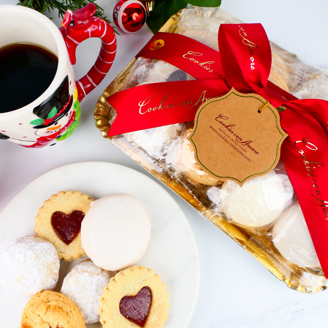 Packaged cookies with a red ribbon and a cup of coffee on a white surface