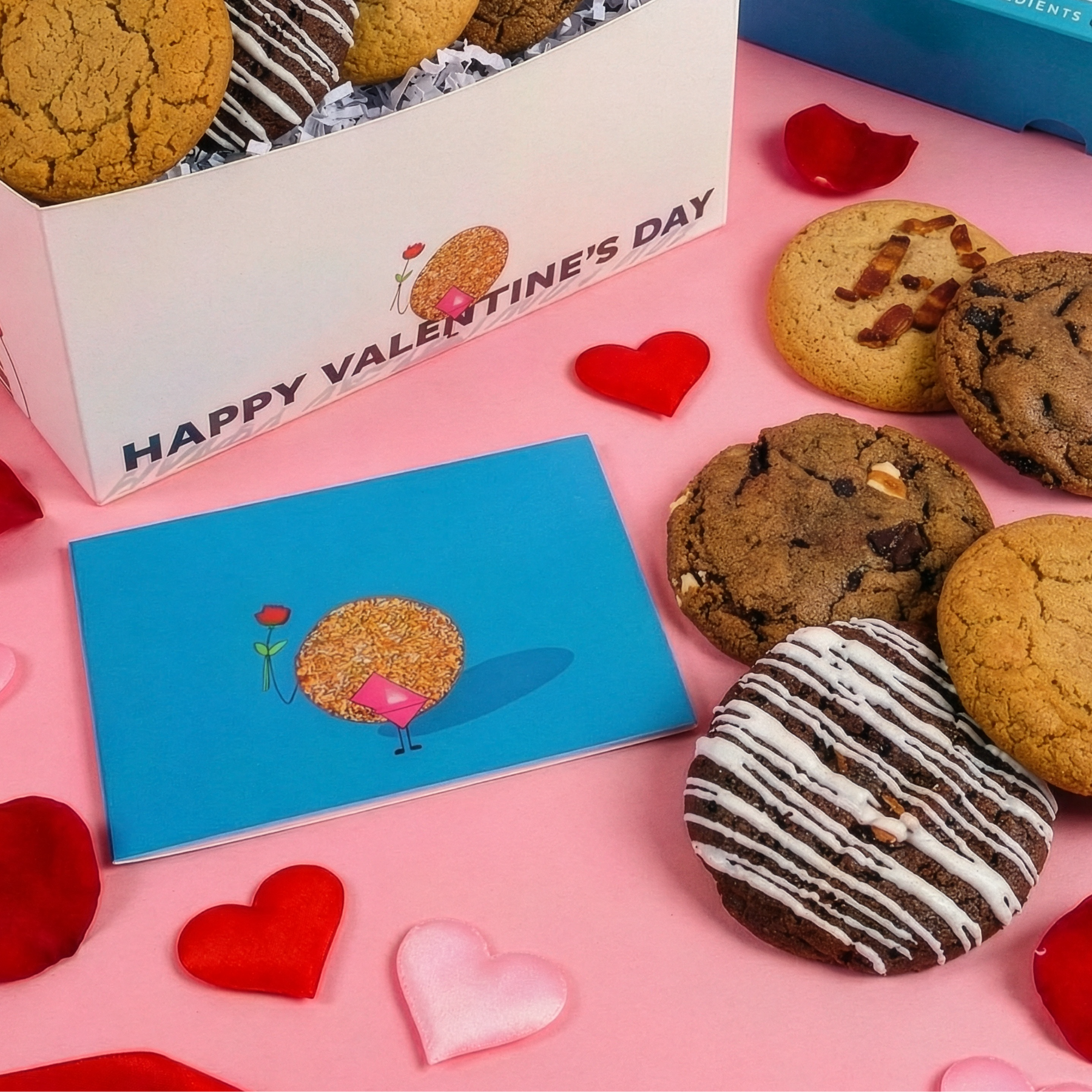 Adventurous Mix cookies on a pink surface with Valentine's Day cards and decorations.